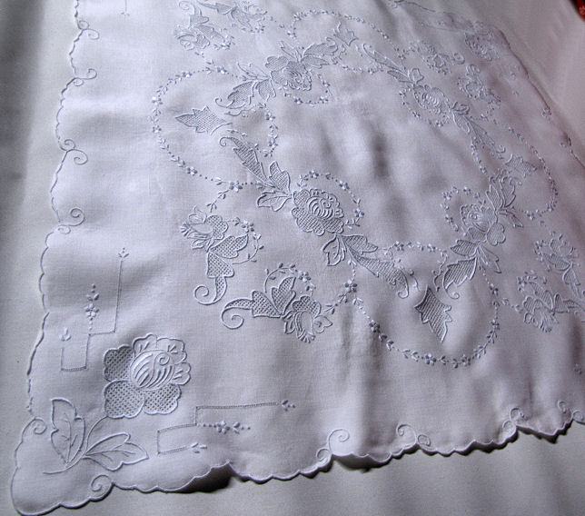 close up vintage antique white linen table topper with handmade Appenzell lace and blue embroidery