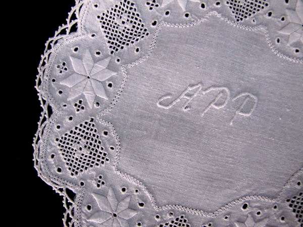 close up vintage white linen doily with handmade lace and embroiderey