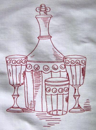 close up vintage antique table runner or wall hanging hand embroidered redwork wine carafe