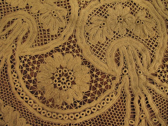 close up vintage antique handmade round battenberg lace tablecloth