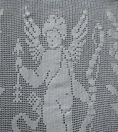 close up vintage antique handmade figural lace table topper with cupid