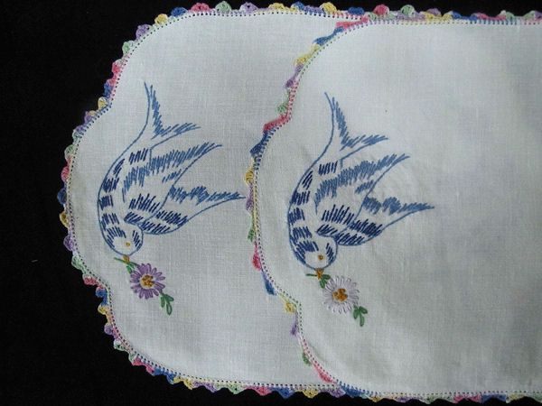 close up pair vintage antique bluebird doilies handmade lace and embroidery