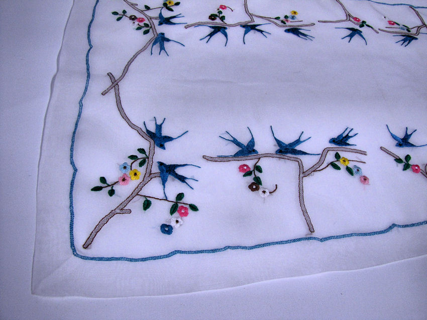 close-up vintage  antique handmade organdy table runner hand embroidered blue birds